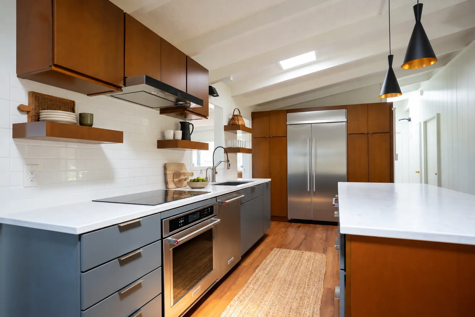 Open kitchen after the enclosing walls were removed, with clear circulation between the island and cabinetry